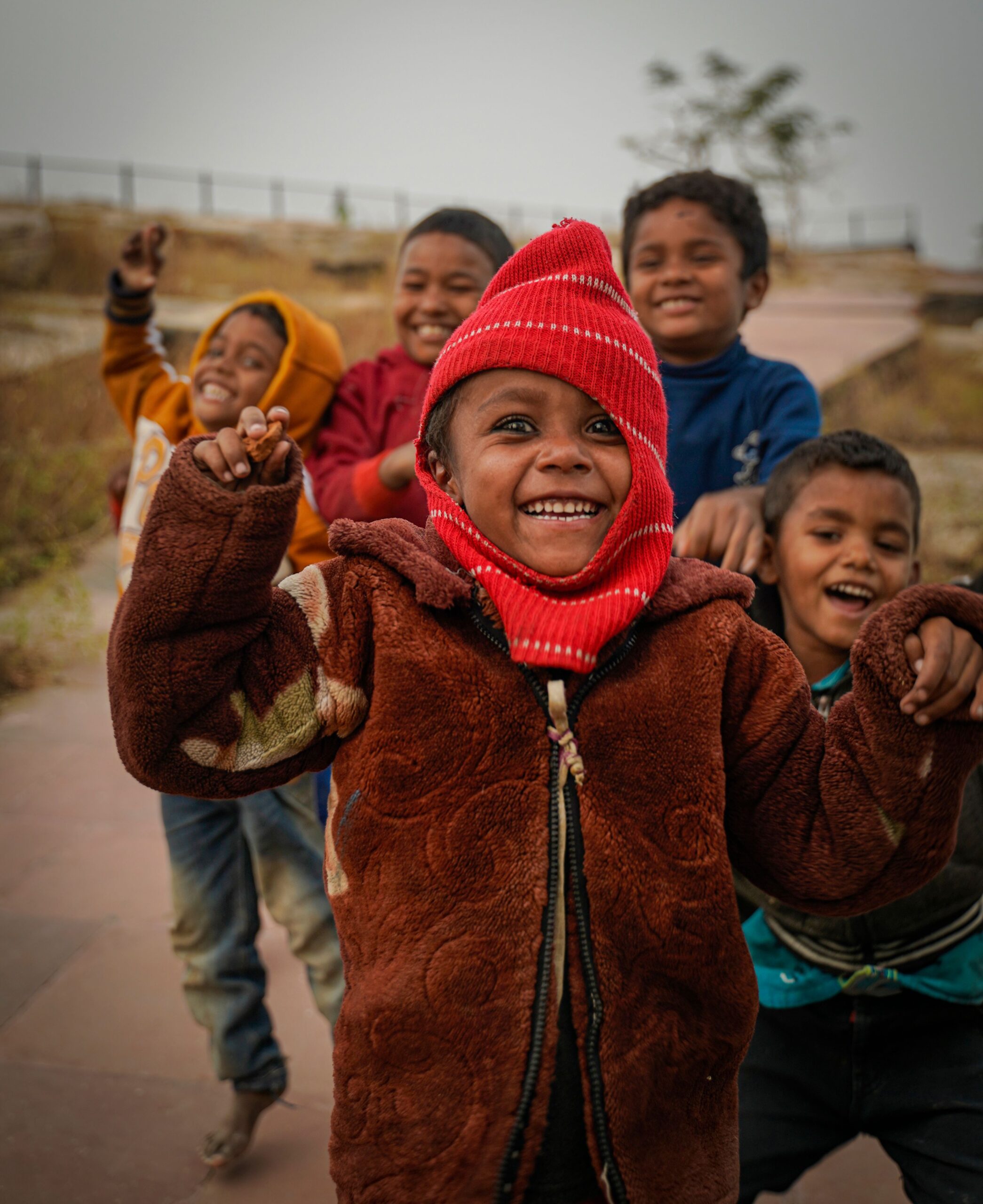 Group of happy children enjoying playtime outside in winter gear. Candid and carefree moments captured.