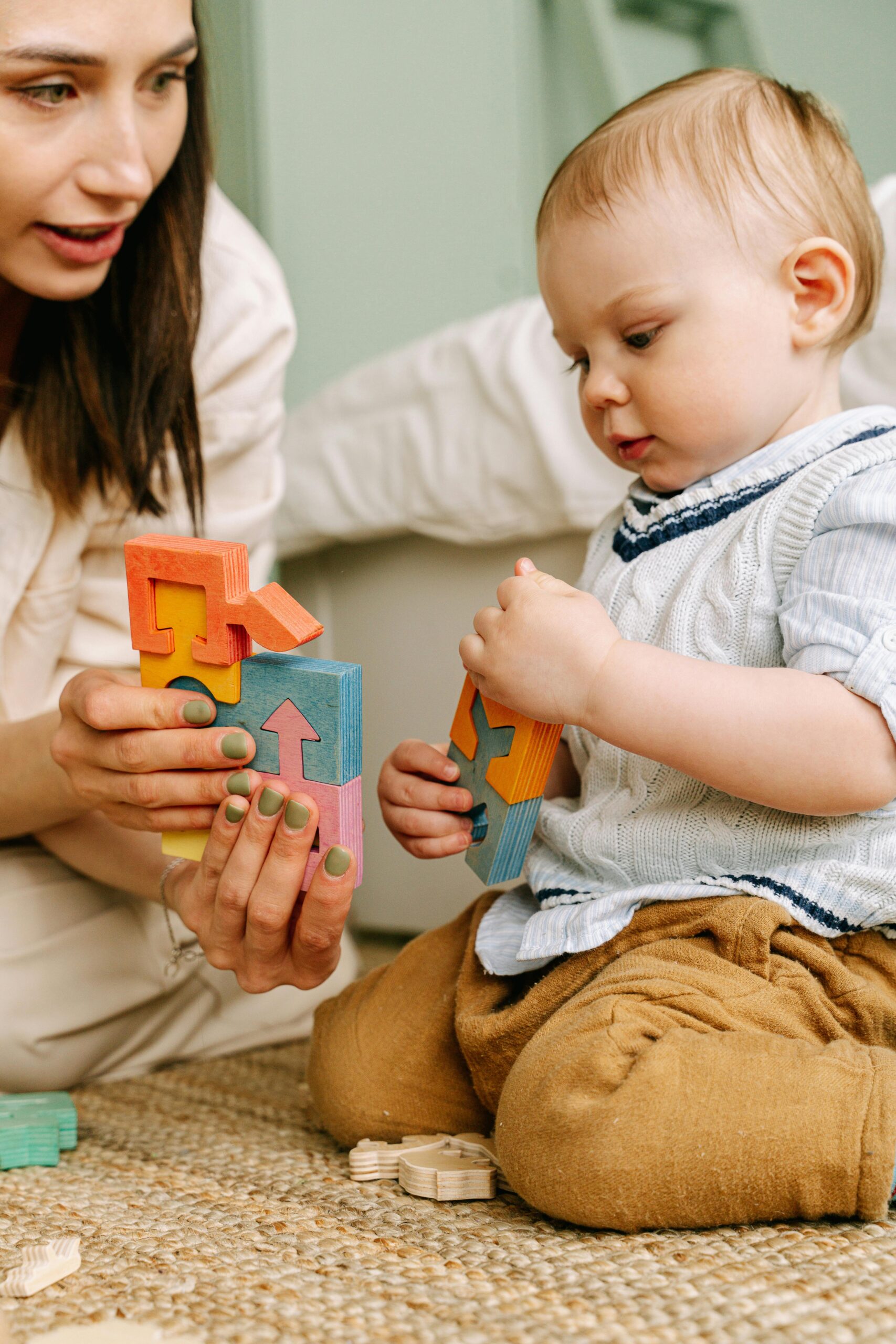 A mother and baby enjoying quality time together playing with colorful wooden blocks.